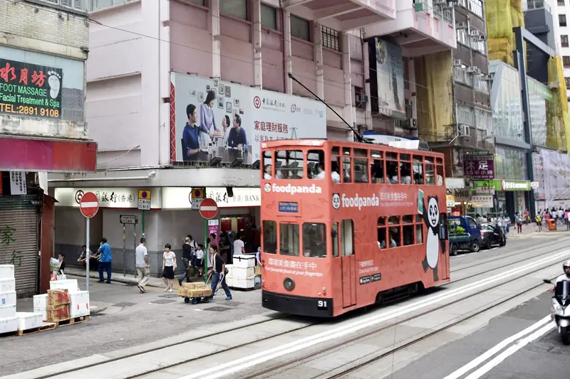 紅色雙層電車行經老舖林立嘅街道