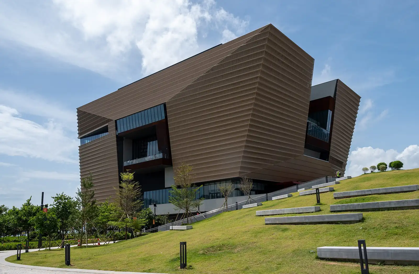香港故宮文化博物館古銅色外牆,前面係斜草坪