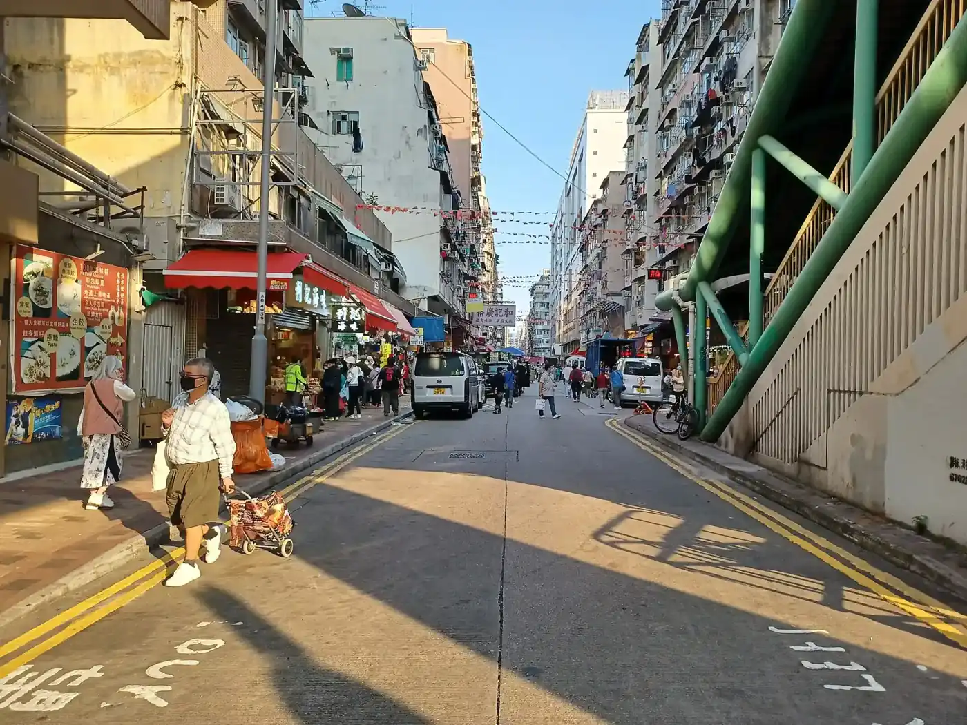 陽光下嘅深水埗基隆街,有行人同天橋