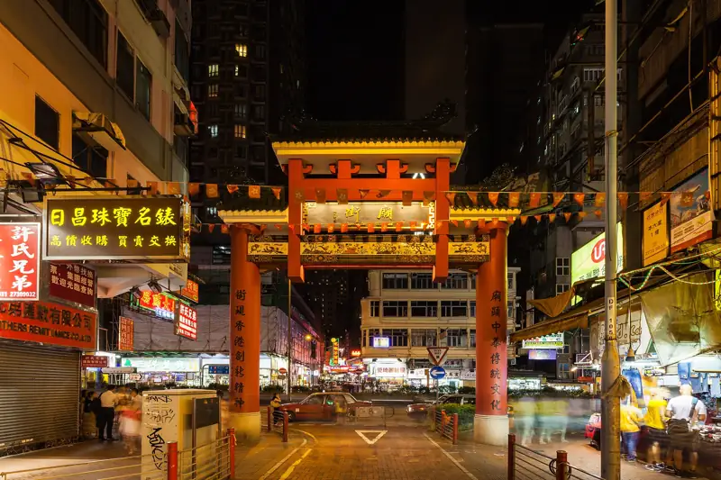 廟街牌樓橫跨街道,兩旁霓虹招牌